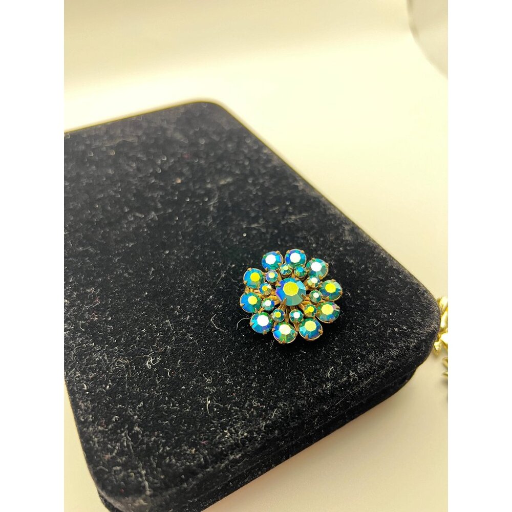 Vintage gold tone aurora borealis blue rhinestone flower shaped brooch rivets